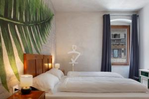 a bedroom with a large bed with a large window at Edelweiss Alp Rooms in Castello Tesino