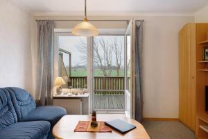 a living room with a blue couch and a window at Ferienwohnungen Carstensen in Nordstrand