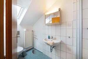 a bathroom with a sink and a toilet at Ferienwohnungen Carstensen in Nordstrand +48 photos
