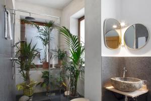 a bathroom with a sink and a mirror and plants at Edelweiss Alp Rooms in Castello Tesino +74 photos