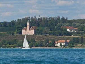 a sailboat on the water in front of a castle at Ferienhaus Jäger in Friedrichshafen
