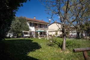 a large white house with a tree in the yard at Villino Ca' Bianca, vicino ad Alba, NO ZANZARE, accessibile e con sollevatori aerei in Monteu Roero