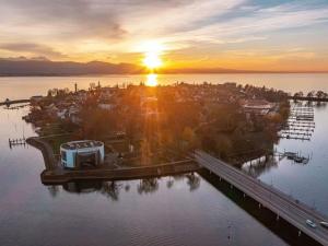 an island in a body of water with the sunset at Ferienhaus Jäger in Friedrichshafen +93 photos