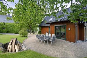 a patio with a table and chairs in front of a building at Ferienhaus Wasserfall in Bestwig