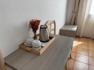 a tray with a tea kettle and plates on a table at Vehí in Cadaqués