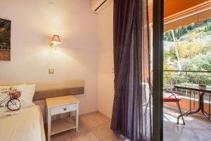 a bedroom with a bed and a balcony at Nontas Homes 34 in Kalamitsi