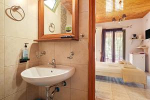 a bathroom with a sink and a mirror at Nontas Homes 34 in Kalamitsi +18 photos