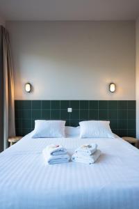 a white bed with towels on top of it at LPM Sporthotel Durbuy in Durbuy +34 photos