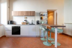 a kitchen with white cabinets and a table and chairs at Somewhere Over the Hills in Terni