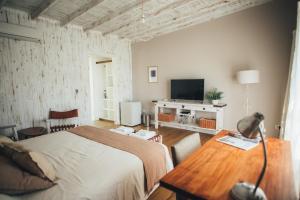 a bedroom with a bed and a table and a television at Posada Las Aguas in Gualeguaychú