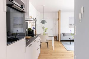 a kitchen with white cabinets and a living room at Steuerbord in Böhl