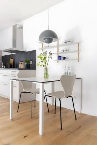 a white kitchen with a white table and chairs at Steuerbord in Böhl +20 photos