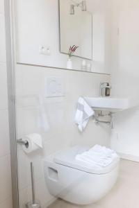 a white bathroom with a toilet and a sink at Steuerbord in Böhl