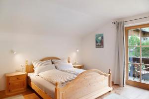 a bedroom with a wooden bed with a window at Ferienwohnung Alpspitznest in Grainau
