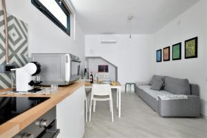 a kitchen and living room with a couch and a table at Appartamentino in Bari Sardo