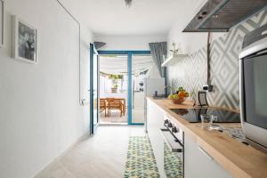 a kitchen with white walls and a blue doorway at Appartamentino in Bari Sardo