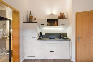 a kitchen with white cabinets and a counter top at Ferienwohnung Hochfelln in Ruhpolding