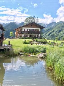 a house with a river in front of it at Ferienwohnung Hochfelln in Ruhpolding
