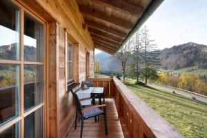 a porch of a cabin with a table and chairs at Ferienwohnung Hochfelln in Ruhpolding +8 photos