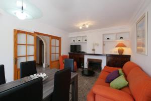 a living room with an orange couch and a table at Ca Na Cati in Muro