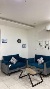 a living room with a blue couch and a table at The Horizon Blue in Zirakpur