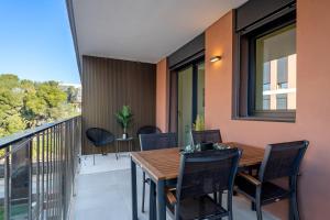a balcony with a wooden table and chairs at Costa Dorada Perle in Calafell