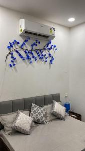 a room with a couch with blue flowers on the wall at The Horizon Blue in Zirakpur