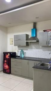 a kitchen with a sink and a refrigerator at The Horizon Blue in Zirakpur
