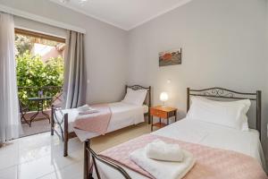 a bedroom with two beds and a balcony at Villa prolithia 2 in Vlikhón