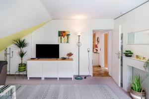 a living room with a tv on a white wall at Ferienwohnung am Rehwinkel in Fuldatal