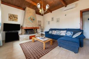 a living room with a blue couch and a fireplace at Villa Rita in Flumini di Quartu