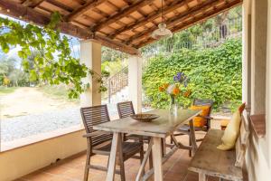 a table and chairs on a patio with a window at Mas Vinyoles 1 in Montnegre