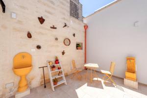 a room with a wall with a toilet and chairs at San Giorgio Rooms in Cavallino di Lecce