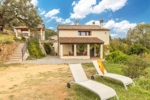 two white chairs in front of a house at Mas Vinyoles 1 in Montnegre