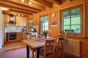a kitchen and dining room with a wooden table and chairs at Geigerseppleshof in Mühlenbach