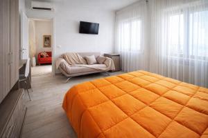 a bedroom with an orange bed and a couch at Villa Merina in Vieste