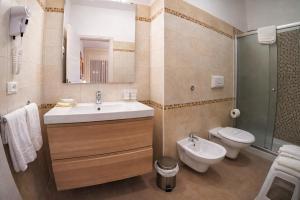 a bathroom with a sink and a toilet and a mirror at Villa Merina in Vieste