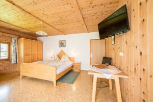 a bedroom with a bed and a flat screen tv at Obermarhof Gsies in Prateria