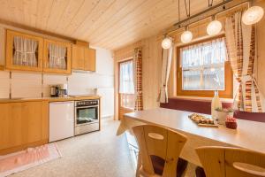 a kitchen with wooden cabinets and a counter with chairs at Obermarhof Gsies in Prateria