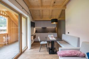 a kitchen and living room with a table and chairs at App. Pedagà - Ciasa Lavarella in San Vigilio Di Marebbe +12 photos