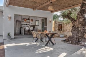a patio with a table and chairs on it at Natura Oliva House in Alikanas