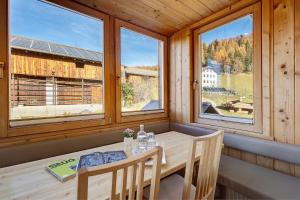 ein Esstisch in einem Zimmer mit Fenstern in der Unterkunft Ciablun in Wengen