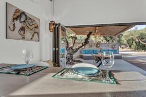a table with plates and wine glasses on it at Natura Oliva House in Alikanas