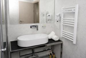 a white bathroom with a sink and a mirror at Hotel Alexandar II in Skopje +56 photos