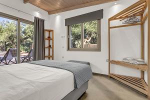 a bedroom with a bed and a balcony at Natura Oliva House in Alikanas