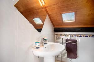 a bathroom with a sink and a ceiling with skylights at Casa do Largo in Mendiga +35 photos