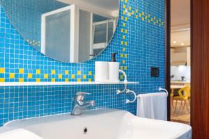 a blue tiled bathroom with a sink and a mirror at Al Civico 1 in Conversano +16 photos