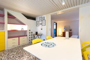 a dining room with a white table and yellow chairs at Al Civico 1 in Conversano
