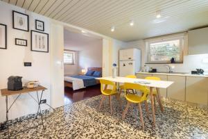 a kitchen with a table and yellow chairs in a room at Al Civico 1 in Conversano