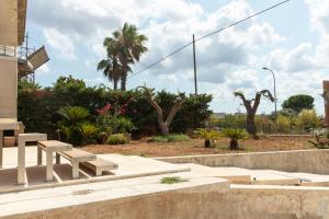 a park with benches and trees and palm trees at Al Civico 1 in Conversano
